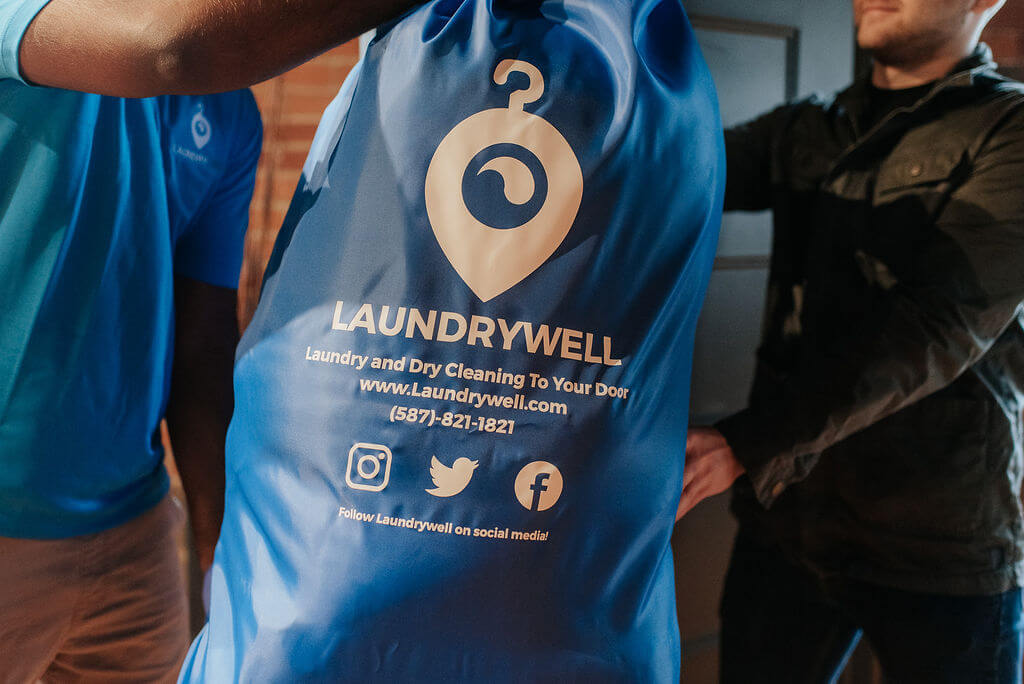 LaundryWell driver giving a customer their laundry